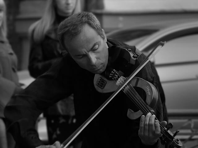 A photo of a man playing an electric violin skillfully.